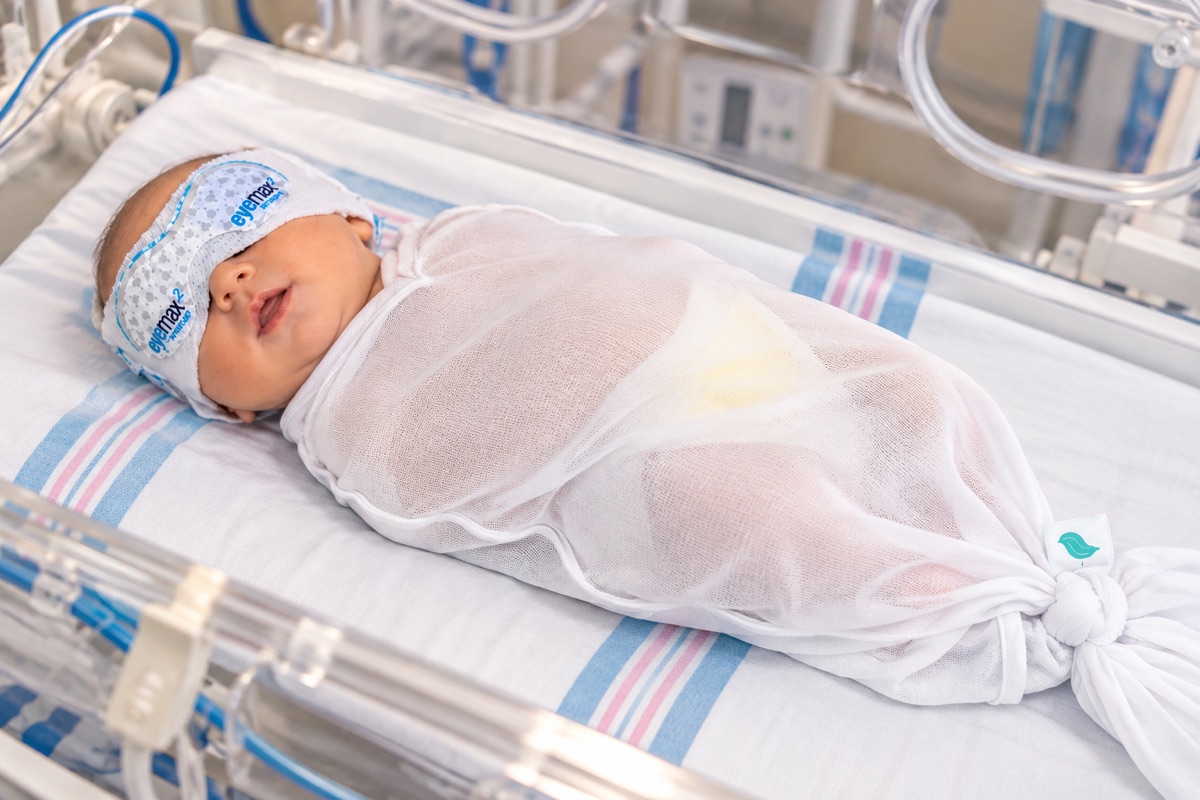 Newborn wearing the feather swaddle™ during phototherapy